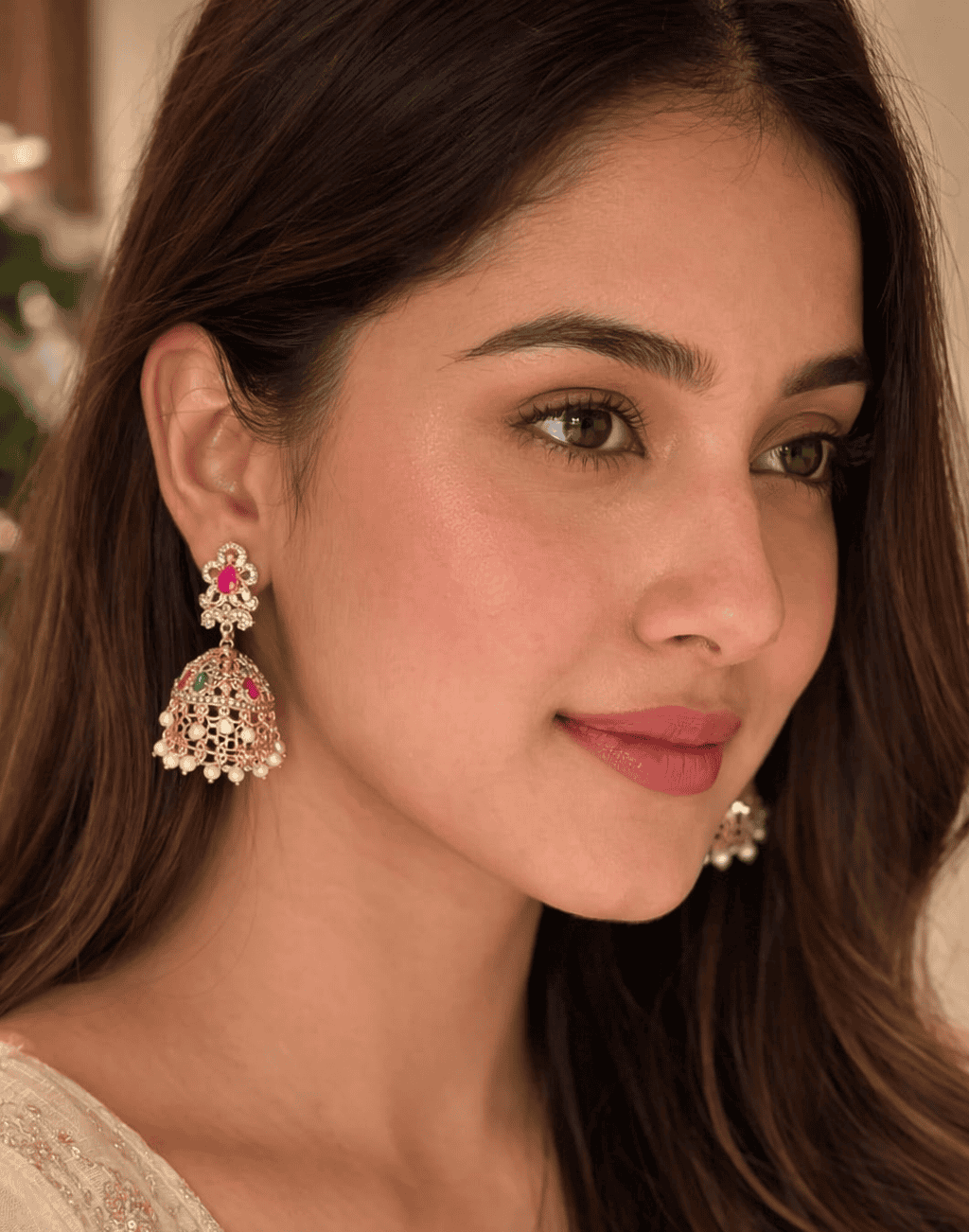 ornate golden jhumkas with ruby emerald accents and delicate pearl fringes