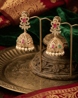 ornate golden jhumkas with ruby emerald accents and delicate pearl fringes