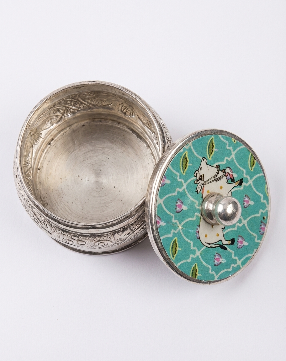 enchanting german silver kumkum box with meenakari cow motif