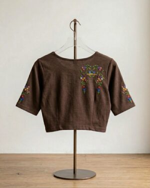 Deep brown stretch banian material saree blouse with colorful floral printed designs on the bodice and sleeves, displayed on a hanger stand