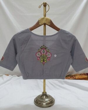 Muted grey stretch banian material saree blouse featuring a vibrant pink and green floral printed motif on the front and sleeves, displayed on a hanger stand