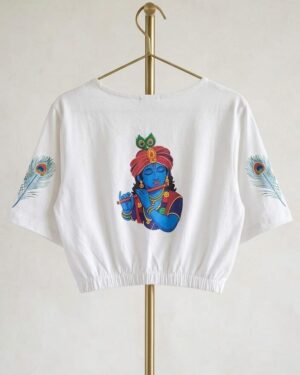 The back of the blouse features a vibrant, artistic print of Lord Krishna playing the flute, flanked by delicate peacock feather designs on the sleeves.