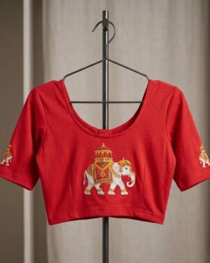 Vibrant red stretch banian material saree blouse with a royal white elephant printed design on the Back and sleeves, displayed on a black clothing hange