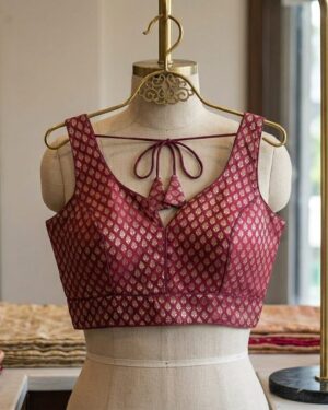 Front view of a wine-colored Banarasi silk blouse featuring gold zari motifs on a mannequin.