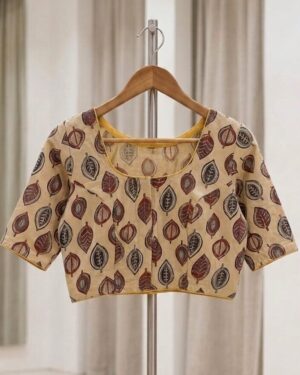 A beautiful beige cotton blouse with maroon and blue leaf-print patterns displayed on a hanger with a stand against a neutral background.
