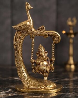 A detailed close-up shot of a handcrafted solid brass Lord Ganesha idol seated on a hanging chain swing