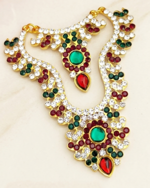 An opulent Exquisite god idol chain necklace sparkling with brilliant white stones and vibrant ruby-emerald accents, displayed flawlessly on a neutral surface.