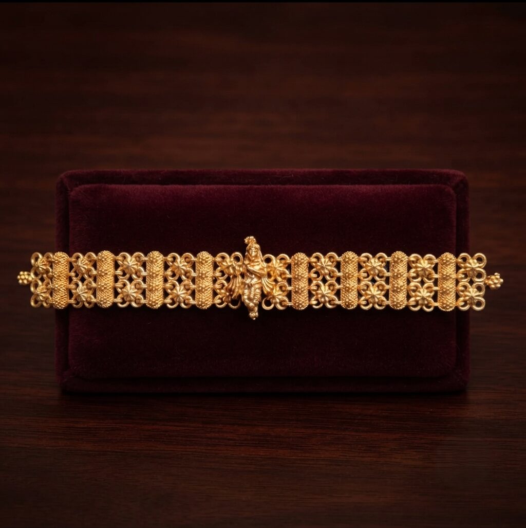 Elegant studio shot of a traditional matte gold Rakhee bracelet highlighting a divine Krishna centerpiece and delicate filigree beadwork against a deep burgundy velvet background.